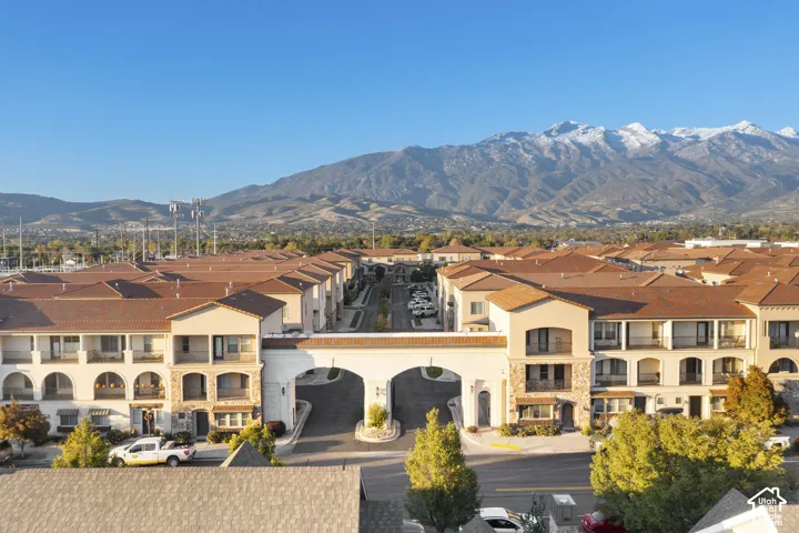 Aerial view featuring stucco exterior architecture, tiled rooflines, arched entryways, covered balconies, and mountain scenery