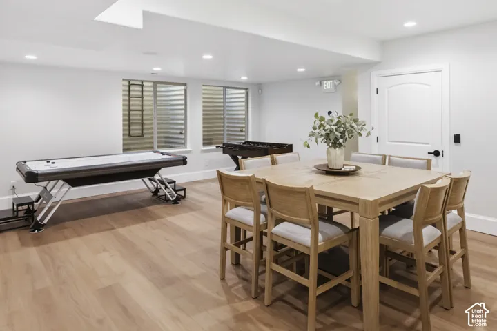 Open-concept room featuring wood-finish flooring, recessed lighting and foosball, air-hockey, game table and games