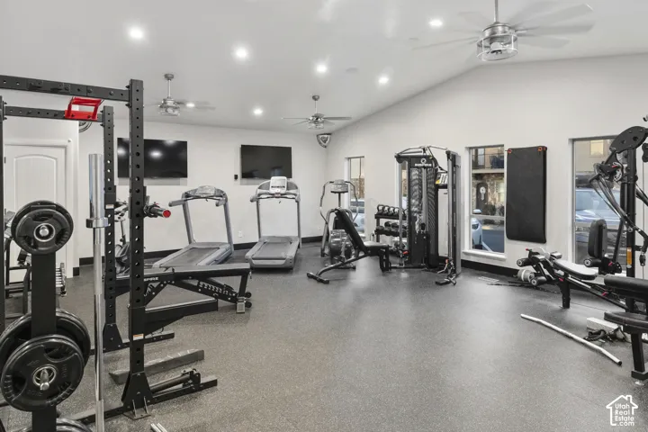 Fitness room featuring high ceilings with recessed lighting, multi-blade ceiling fans, rubberized flooring, and large windows
