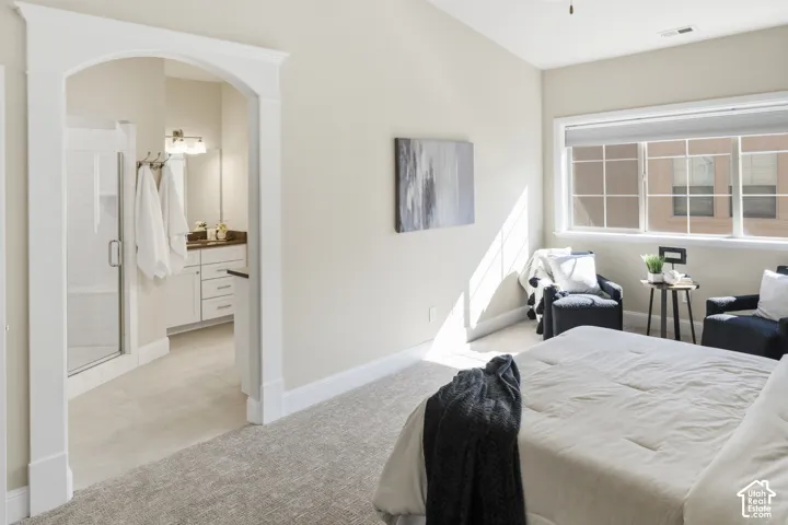 Vaulted ceiling, arched interior doorway with white trim, multi-pane window with custom blinds, and neutral carpeting