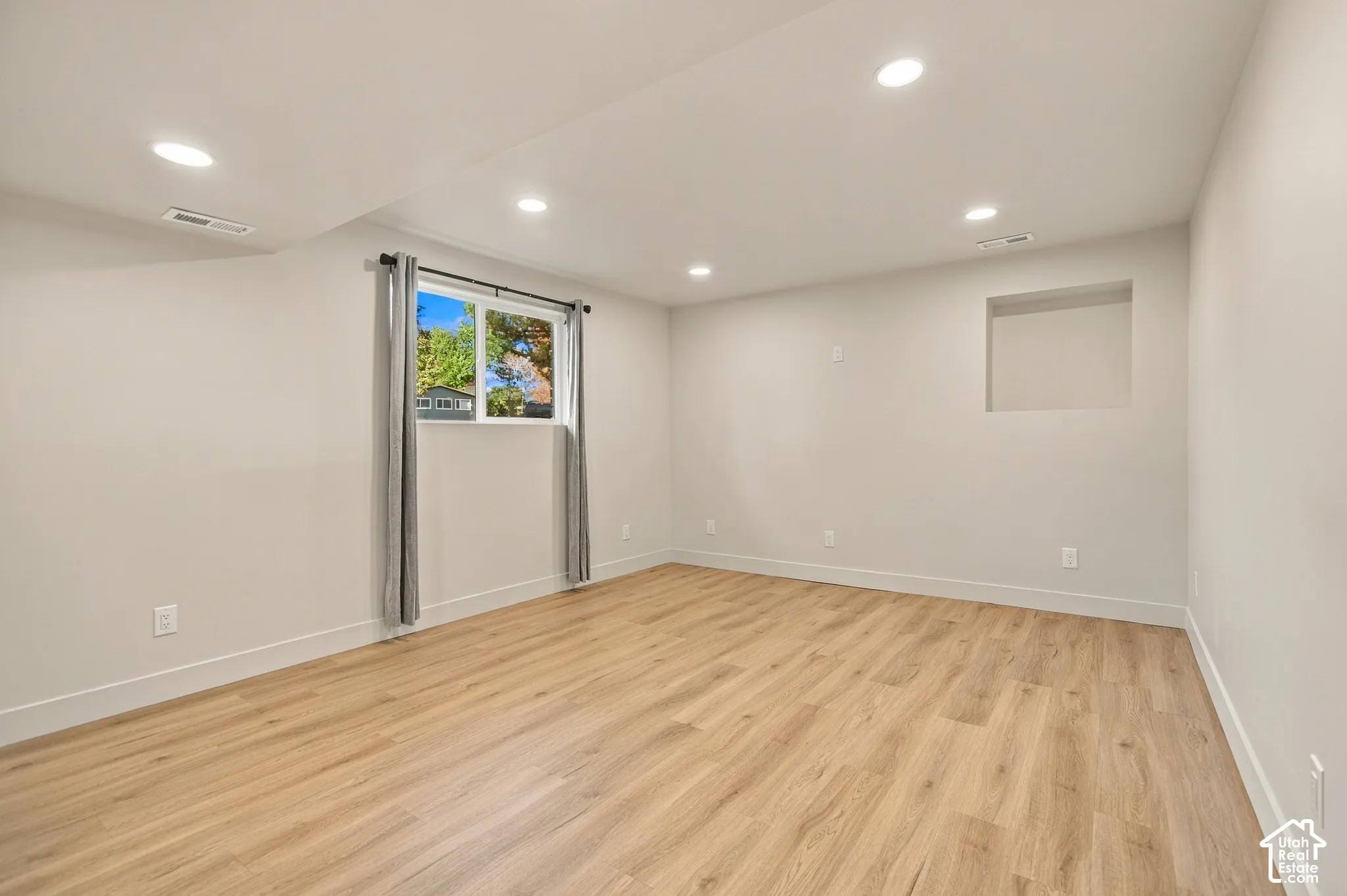 Neutral-toned interior featuring wood-finish flooring, recessed lighting, and a built-in wall niche