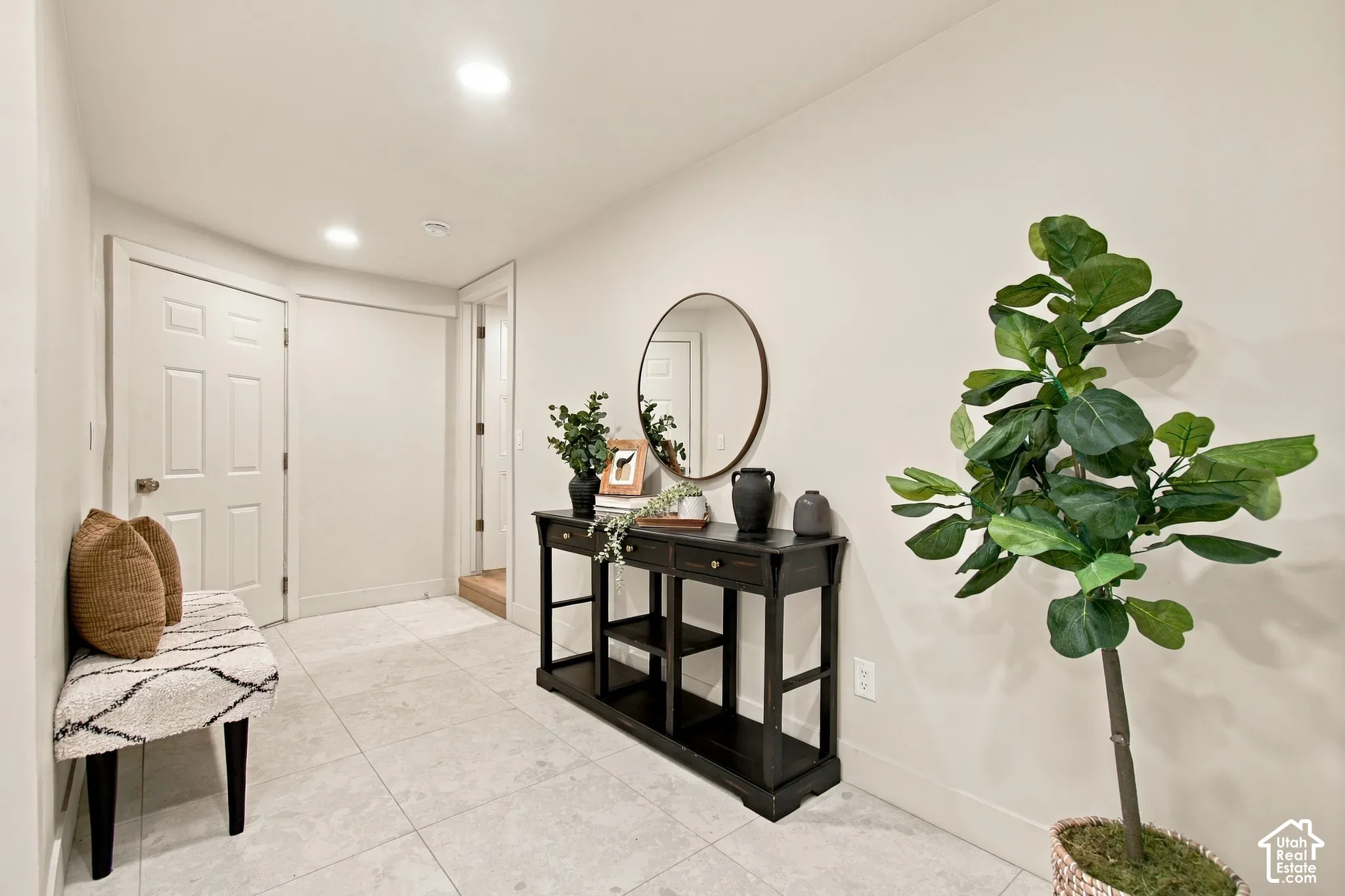 Neutral-toned tile flooring, recessed ceiling lighting, and a six-panel interior door