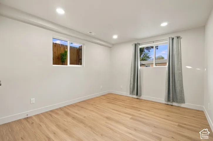 Interior room featuring light wood-finish flooring, recessed lighting, and dual windows