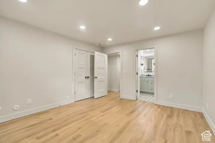 Room featuring wood-finish flooring, recessed lighting, and double-panel doors