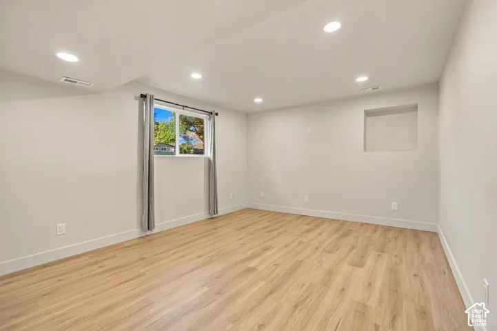 Neutral-toned interior featuring wood-finish flooring, recessed lighting, and a built-in wall niche