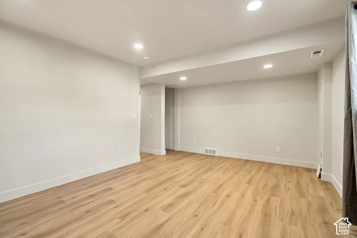 Interior space featuring wood-finish flooring, neutral wall paint, and recessed ceiling lighting