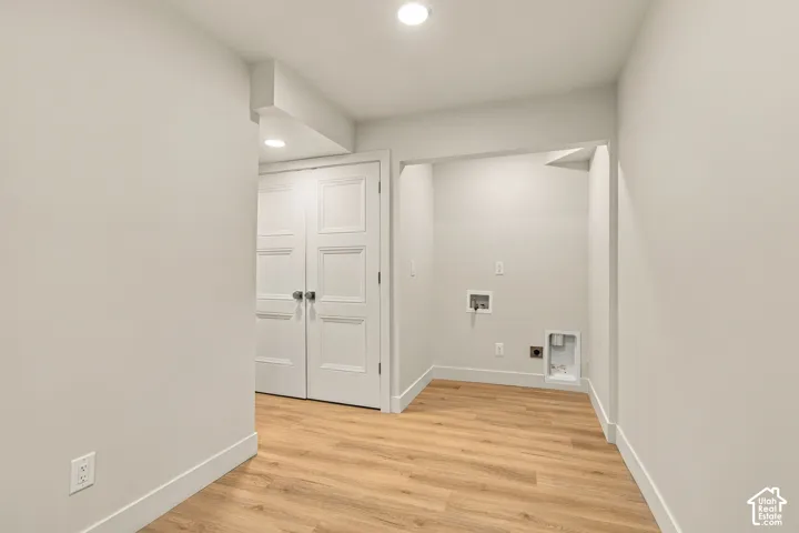 Utility area featuring wood-finish flooring, recessed lighting, and white three-panel interior double doors