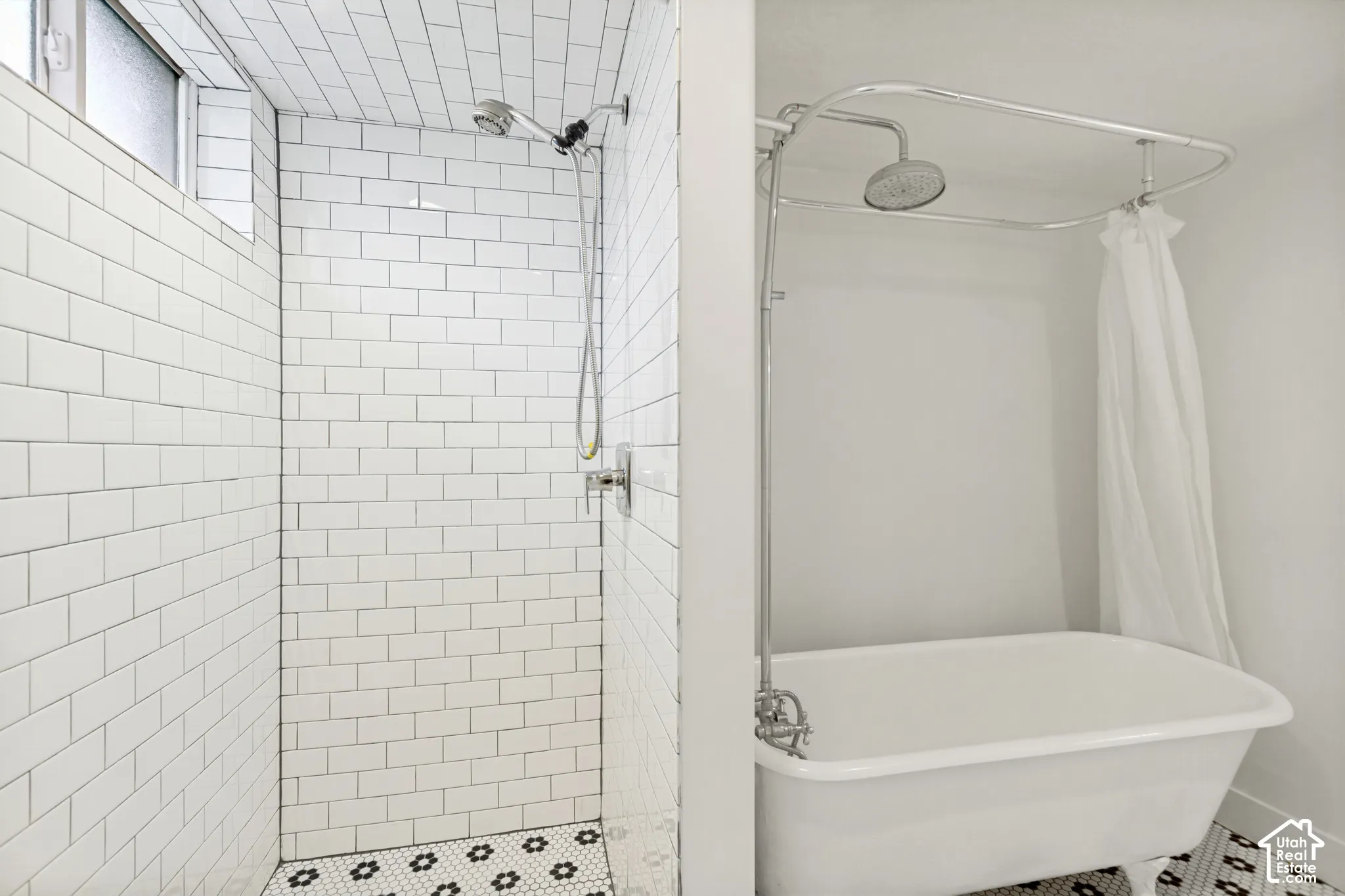 Walk-in shower featuring white subway tile walls and patterned floor tile, paired with a clawfoot soaking tub equipped with a chrome overhead shower fixture