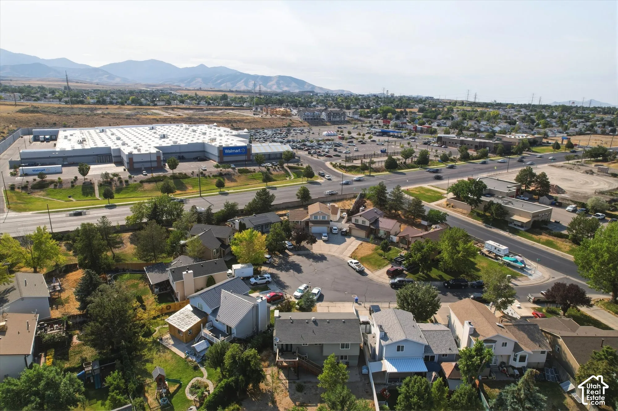 Aerial perspective of the residential area featuring a mountain backdrop and mature trees