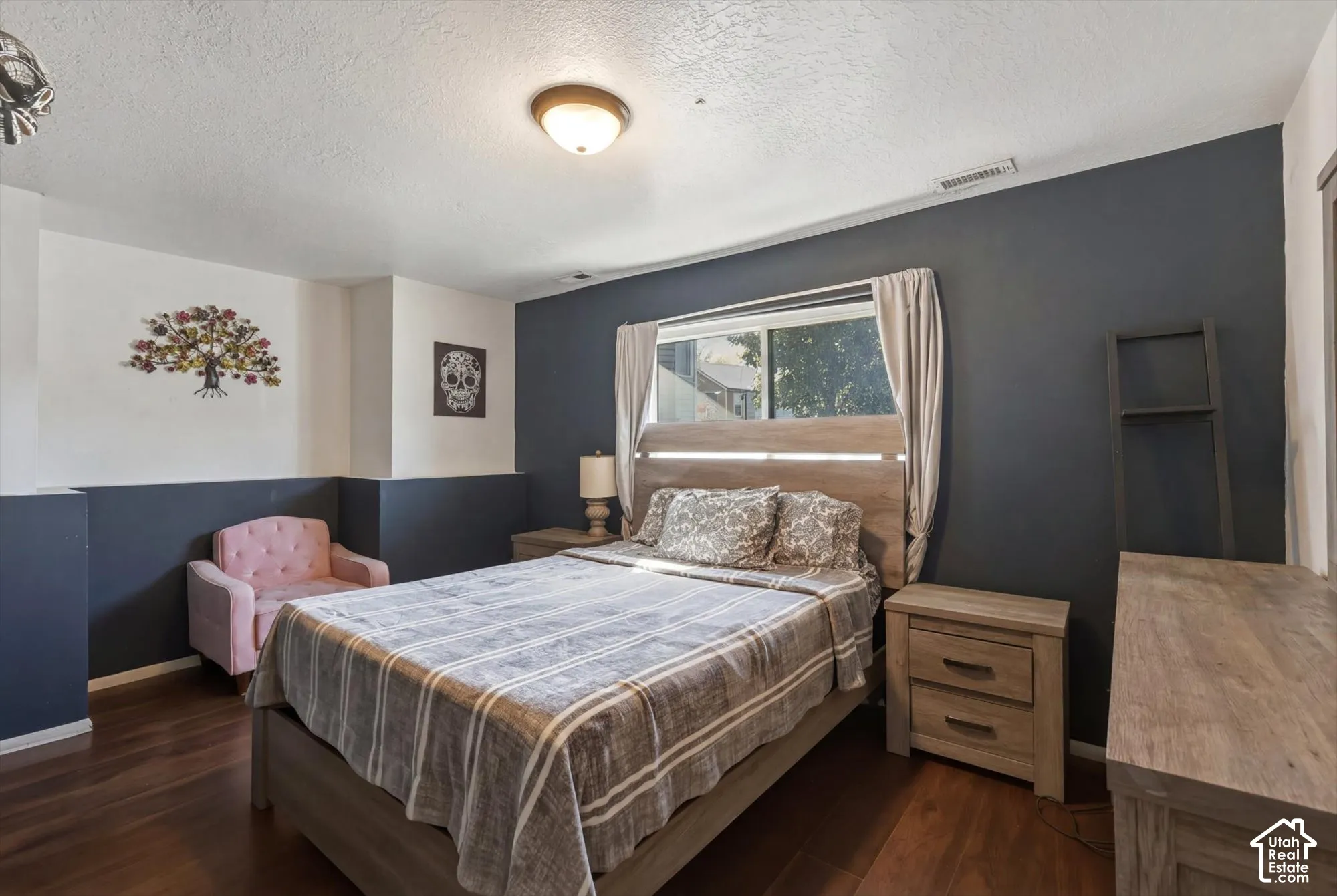 Room featuring wood-finish flooring, two-tone wall paint, and a central dome-style ceiling light fixture