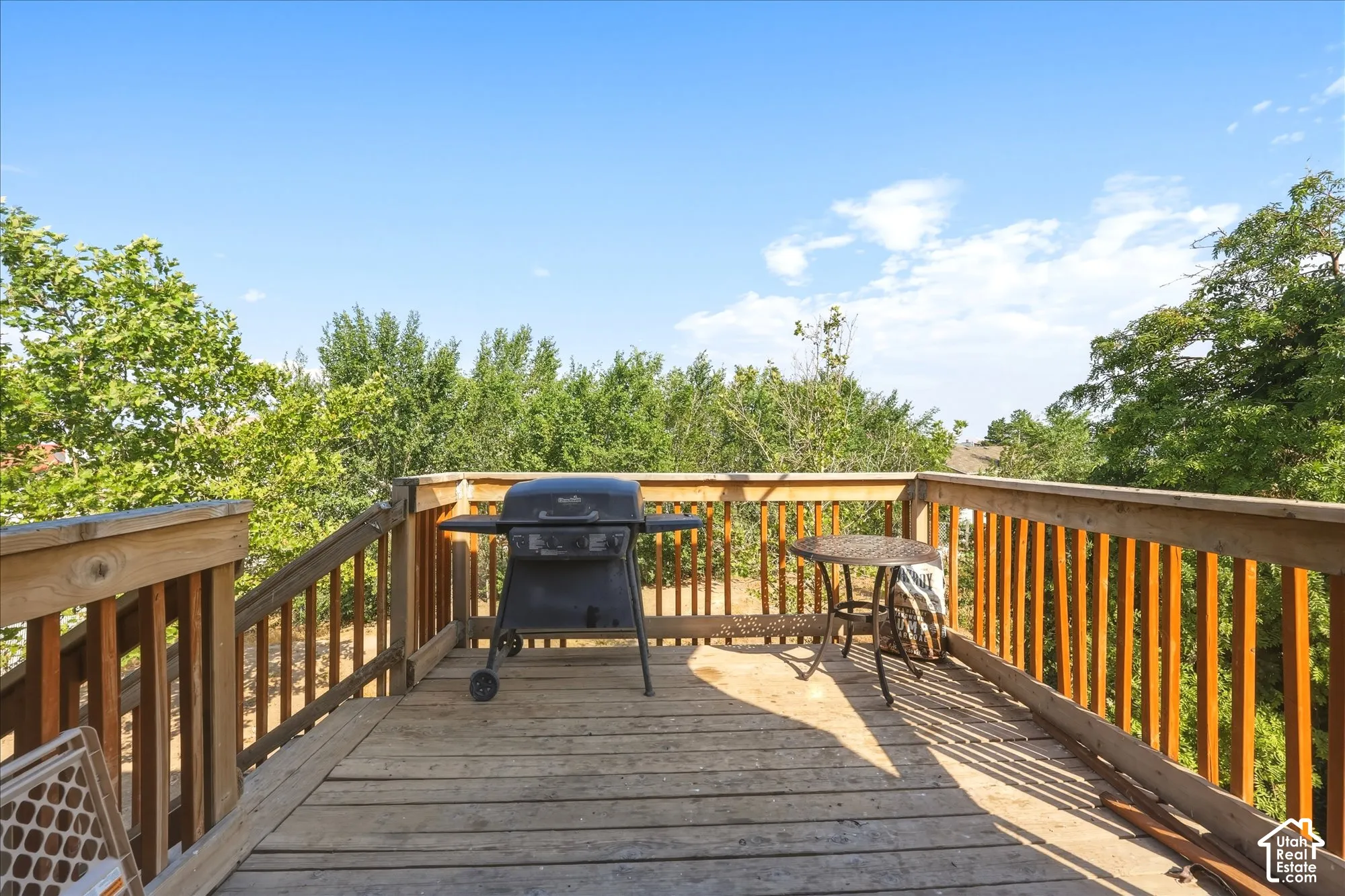 Elevated wooden deck featuring vertical baluster railings and a staircase
