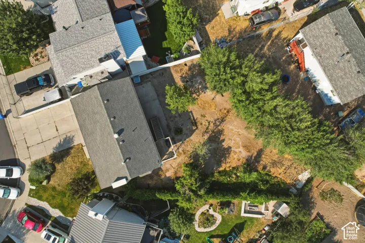 Aerial perspective of property featuring an expansive backyard, mature landscaping, concrete patio, and fenced perimeter
