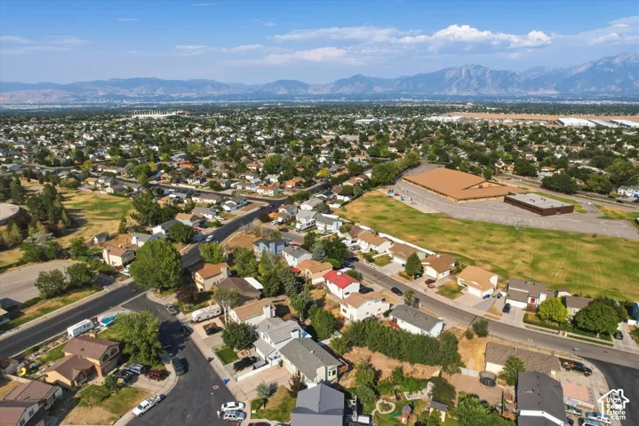 Aerial perspective of the residential area featuring established neighborhood streets, mature landscaping, and a prominent mountain range backdrop