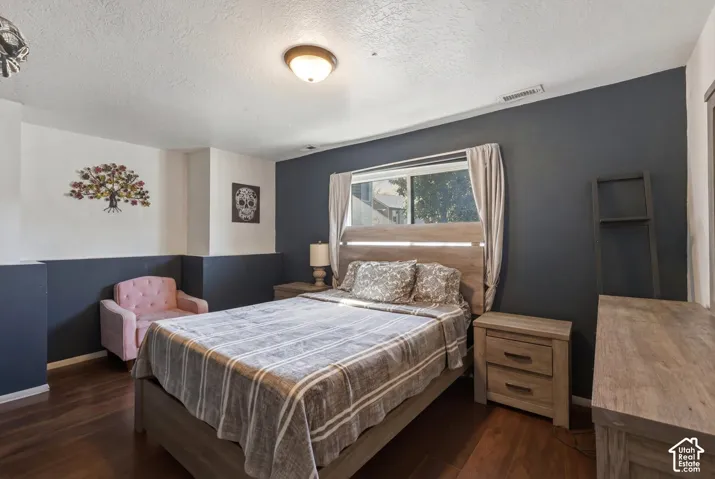 Room featuring wood-finish flooring, two-tone wall paint, and a central dome-style ceiling light fixture