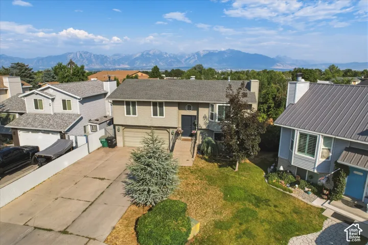 Split-level residence featuring a multi-toned exterior, an attached two-car garage, and a front-facing bay window, complemented by expansive mountain scenery