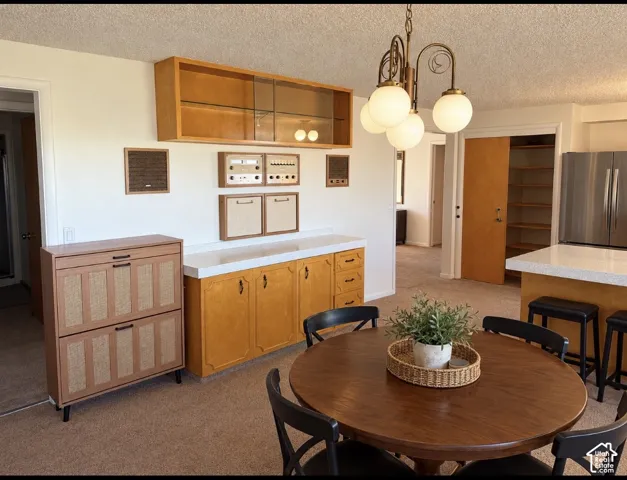 Custom built-in wood cabinetry featuring upper glass-front storage, and integrated electronic components, complemented by a multi-bulb chandelier