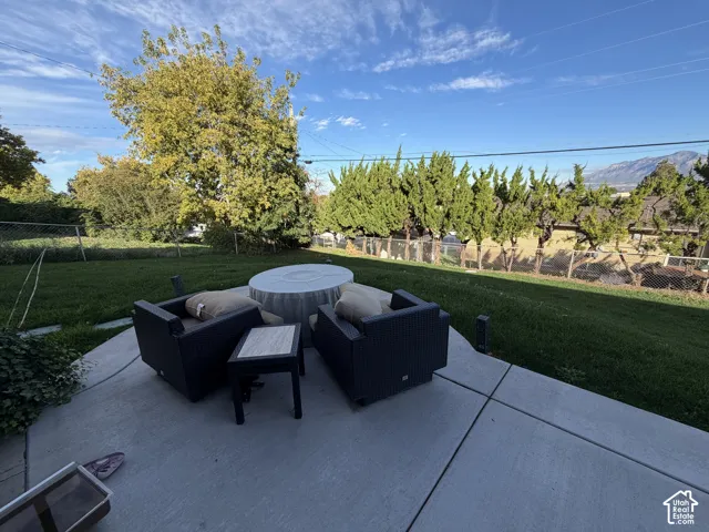 Concrete patio featuring mature trees, and mountain backdrop