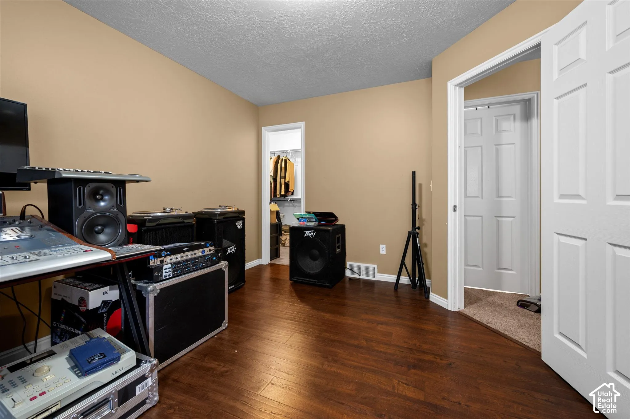 Room featuring wood-finish flooring, white six-panel interior doors, and a walk-in closet