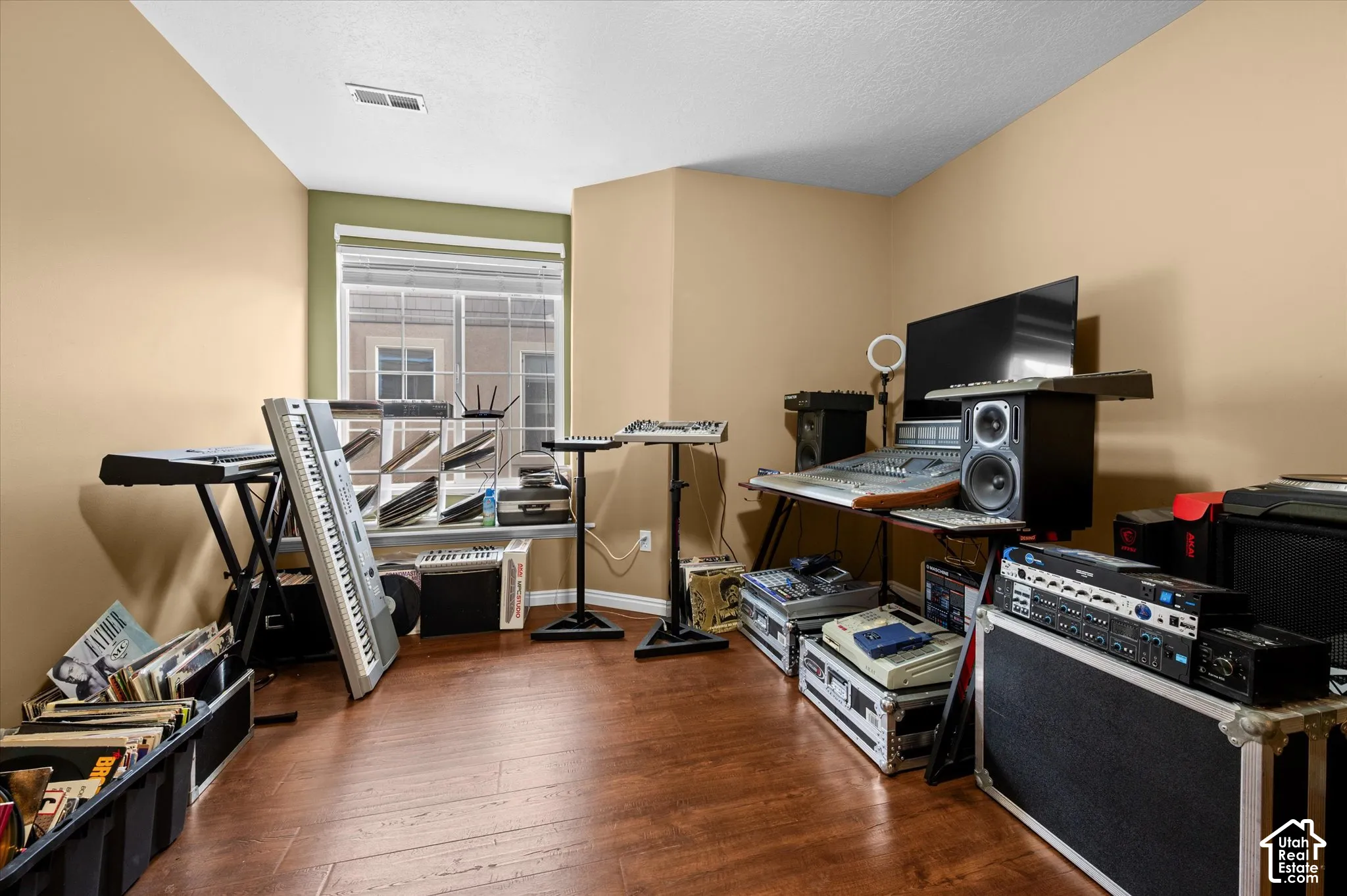 Room featuring wood-finish flooring and a single-pane window with a neutral color palette