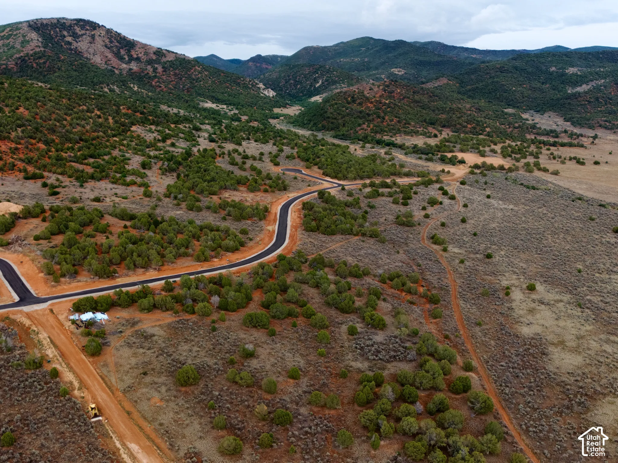 Aerial perspective featuring paved roads, native vegetation, and mountain topography