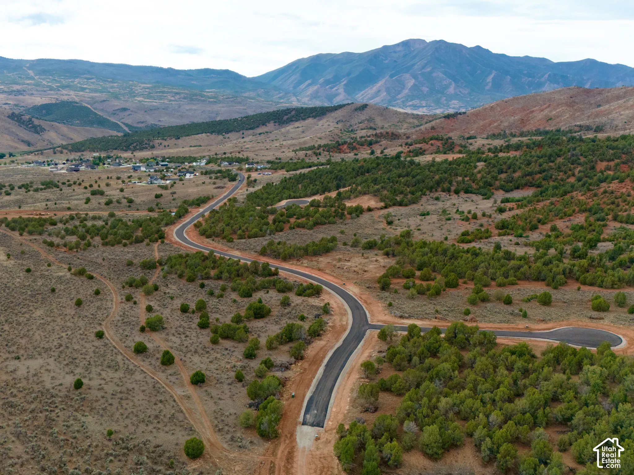 Aerial perspective featuring paved roads, native vegetation, and expansive mountain scenery