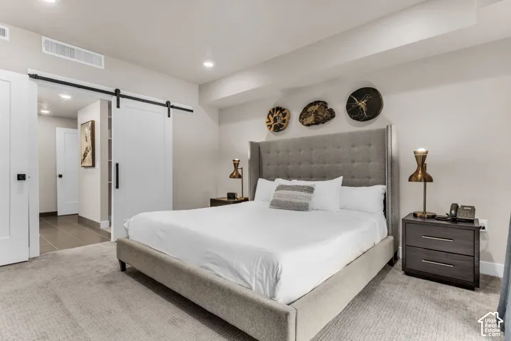 White sliding barn door with black hardware, neutral wall tones, and recessed lighting