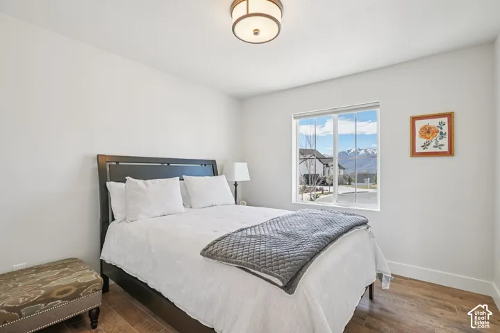 Neutral-toned walls, wood-finish flooring, single-light ceiling fixture, and large window with mountain backdrop