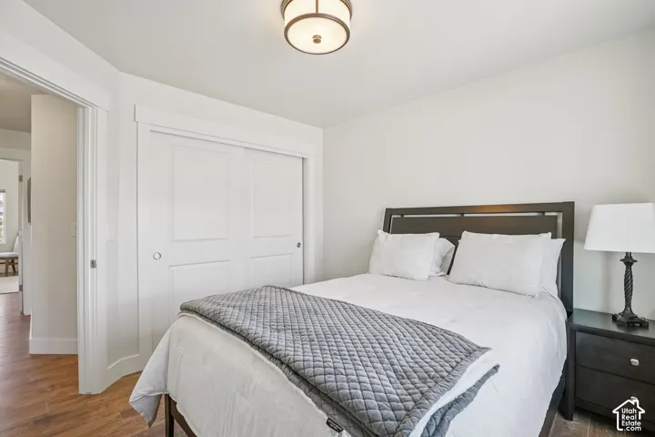 Room featuring wood-finish flooring, white door casings, a dual-panel sliding closet door, and a circular flush-mount ceiling light fixture