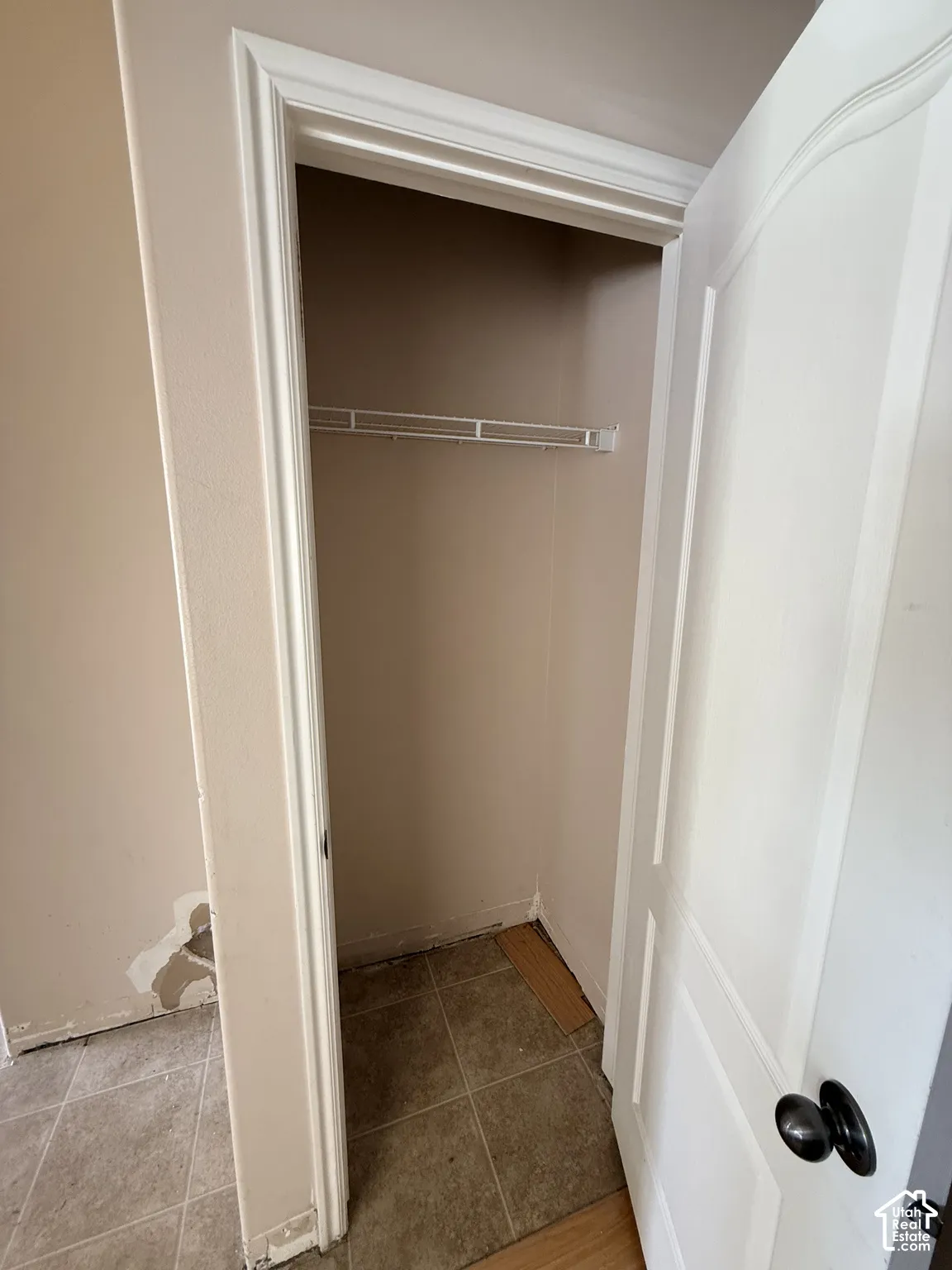 Closet featuring a white paneled door, black hardware, and an installed wire shelf