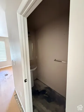 Pedestal sink featuring a wall-mounted mirror and metallic towel bar