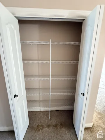 Built-in closet featuring white paneled double doors and five-tier wire shelving