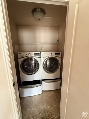 Laundry area featuring large-format ceramic tile flooring, built-in wire shelving, and a dome-style overhead light fixture