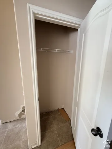 Closet featuring a white paneled door, black hardware, and an installed wire shelf