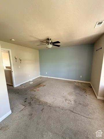 Interior space featuring a central brushed-nickel ceiling fan with integrated lighting and a prominent blue accent wall