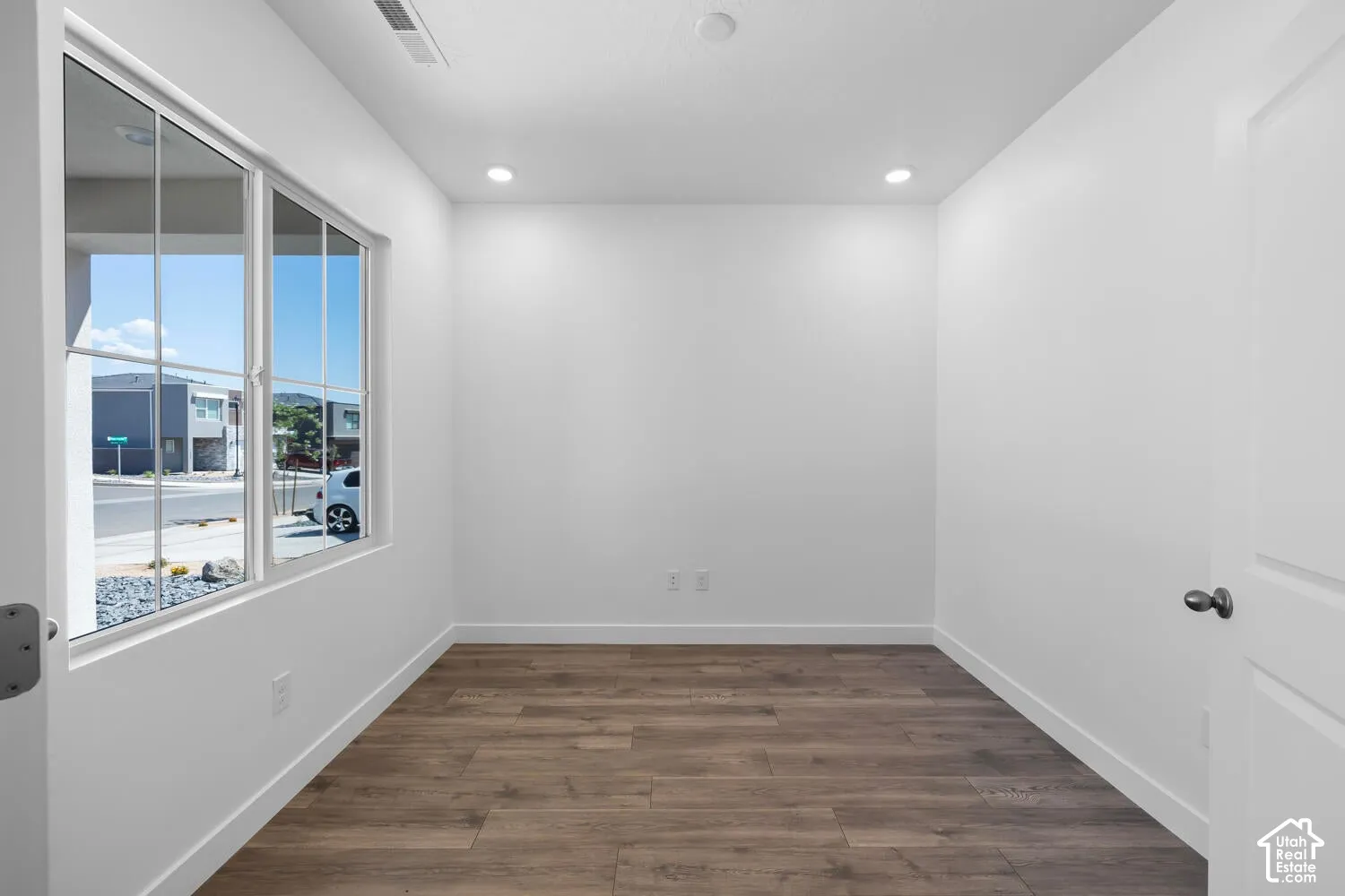 Interior room featuring wood-finish flooring, recessed lighting, and a large multi-pane window