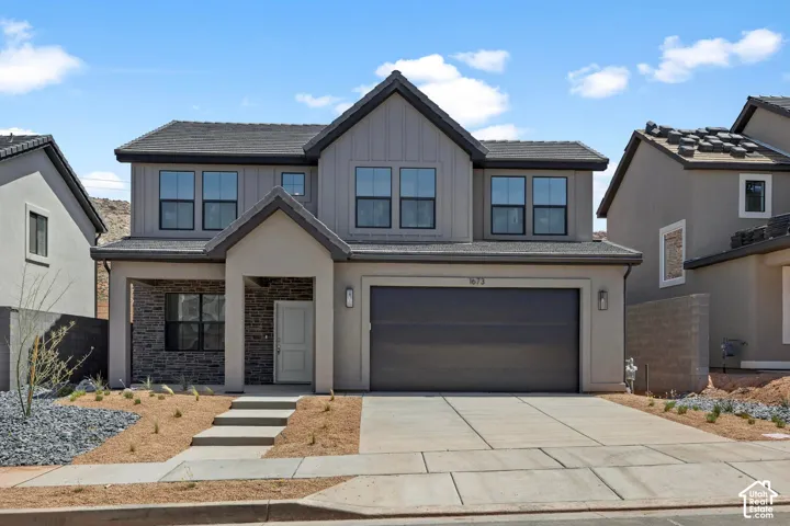 Two-story residence featuring a board-and-batten facade, stone veneer accents, an attached two-car garage, and concrete hardscaping