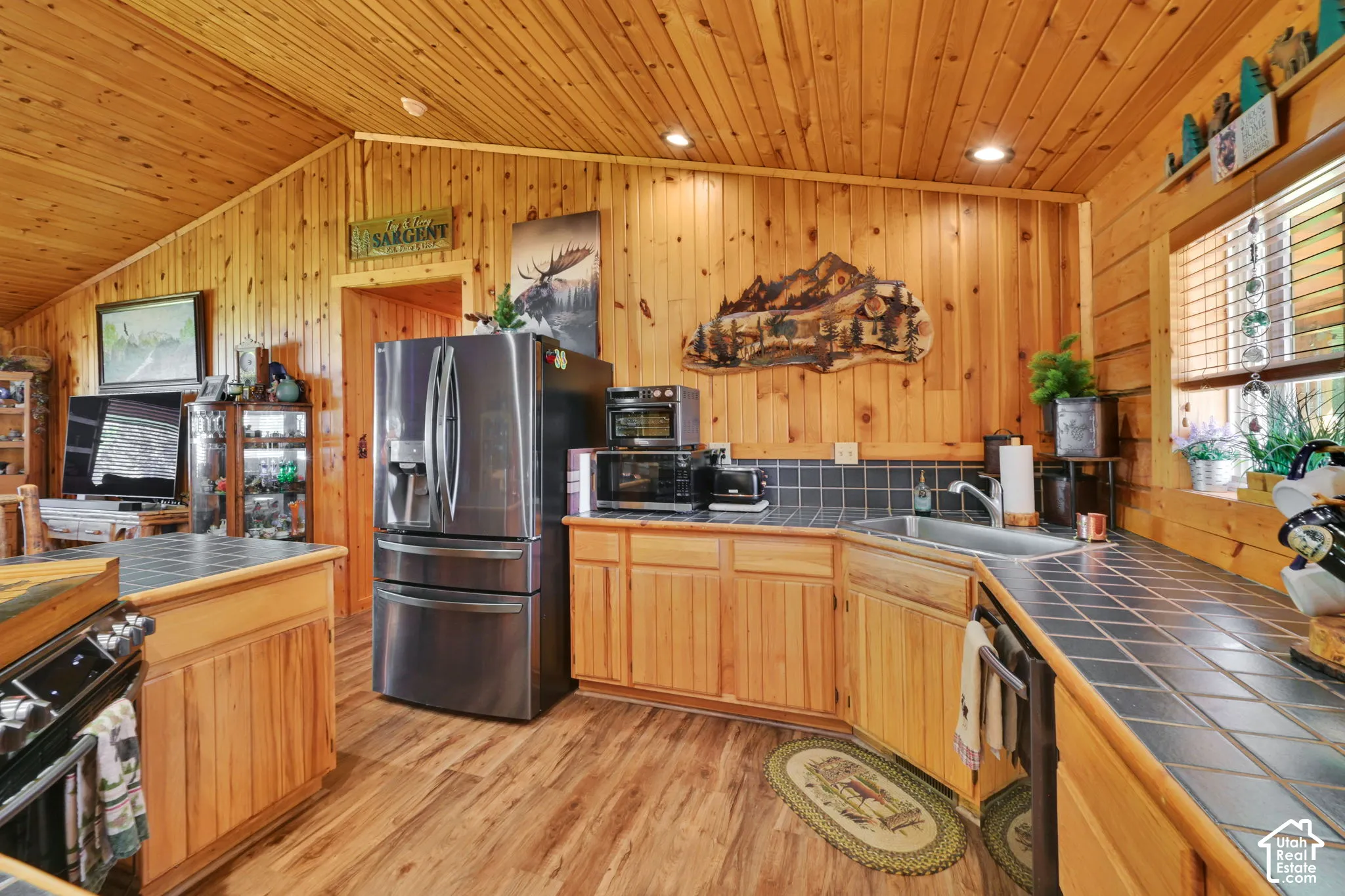Open Kitchen with immaculate wood detailing, vaulted ceiling and island.