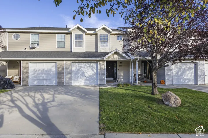 Multi-unit exterior featuring horizontal siding, dual-gabled rooflines, concrete driveways, and private single-car garages