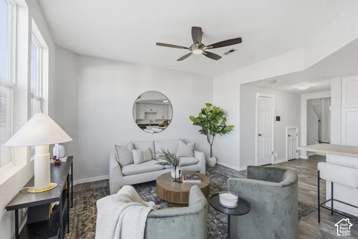 Living area featuring wood-finish flooring, a ceiling fan, and multi-panel windows