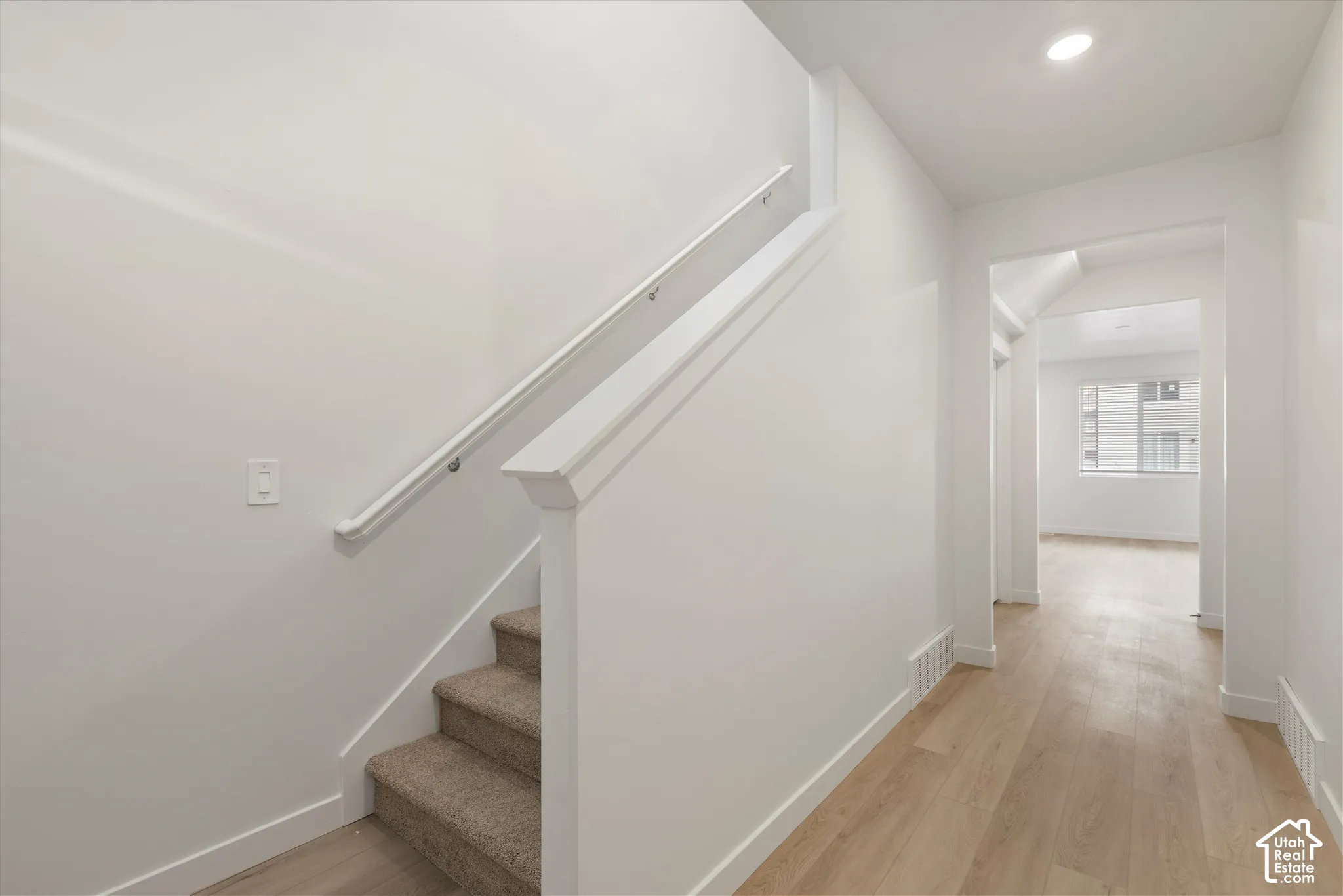 **Disclaimer** Interior package & colors may vary.  Interior hallway featuring wood-finish flooring, recessed lighting, and carpeted staircase with a white handrail