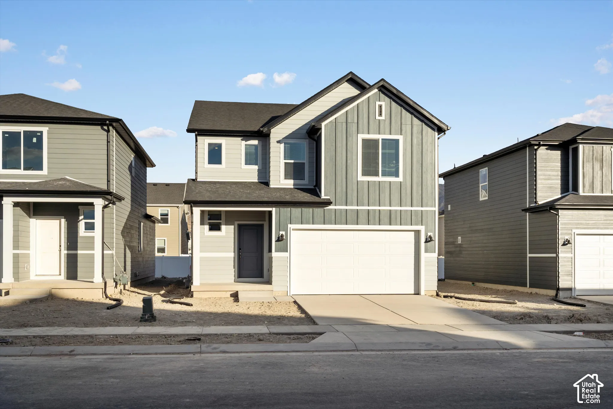 **DISCLAIMER** Elevation and exterior colors may vary.  Two-story exterior featuring a mix of horizontal lap and vertical board-and-batten siding, a dual-material facade, a front-facing attached two-car garage, and asphalt shingle roofing