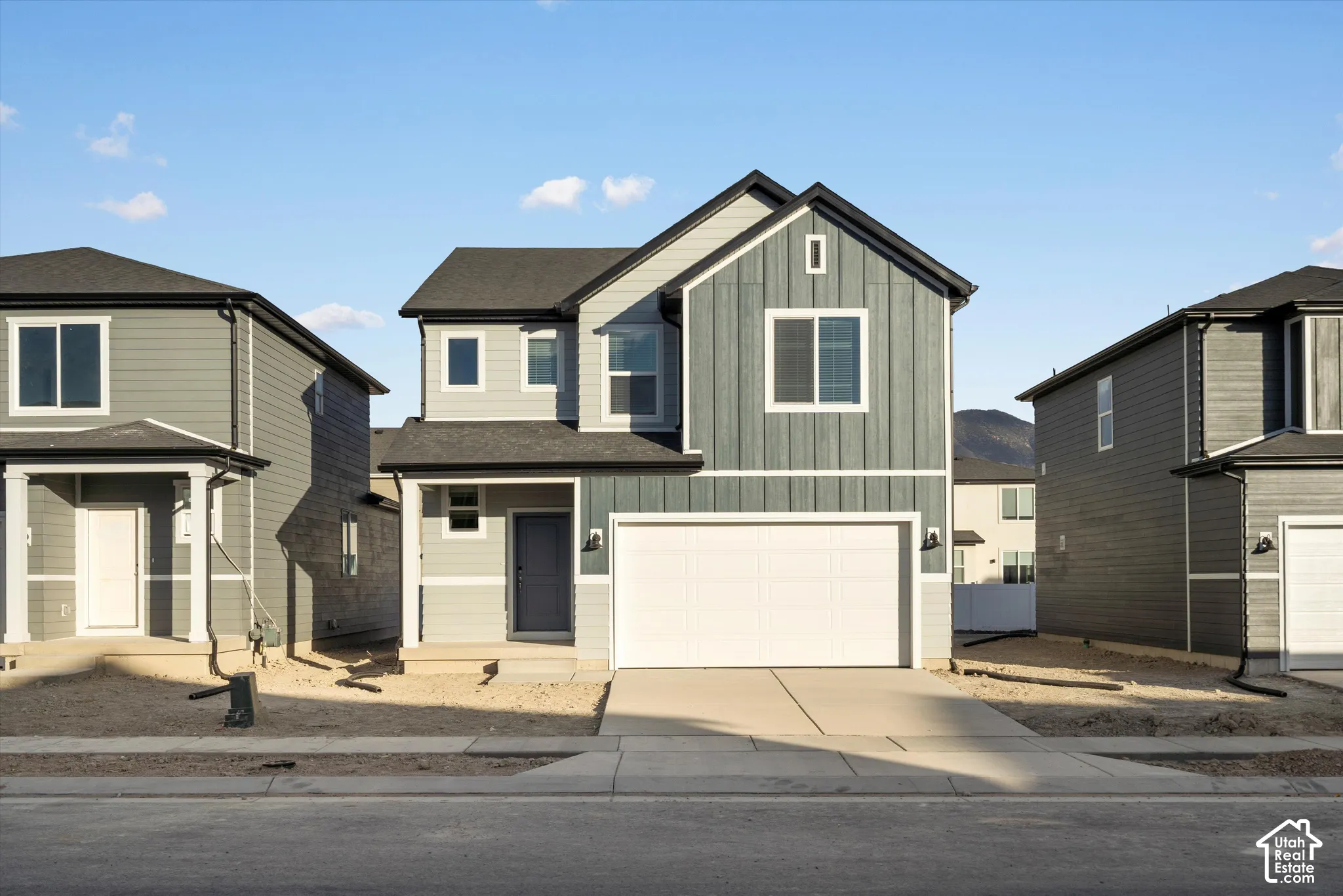 **DISCLAIMER** Elevation and exterior colors may vary.  Two-story exterior featuring vertical board-and-batten and horizontal lap siding, an attached two-car garage, and a covered front entryway