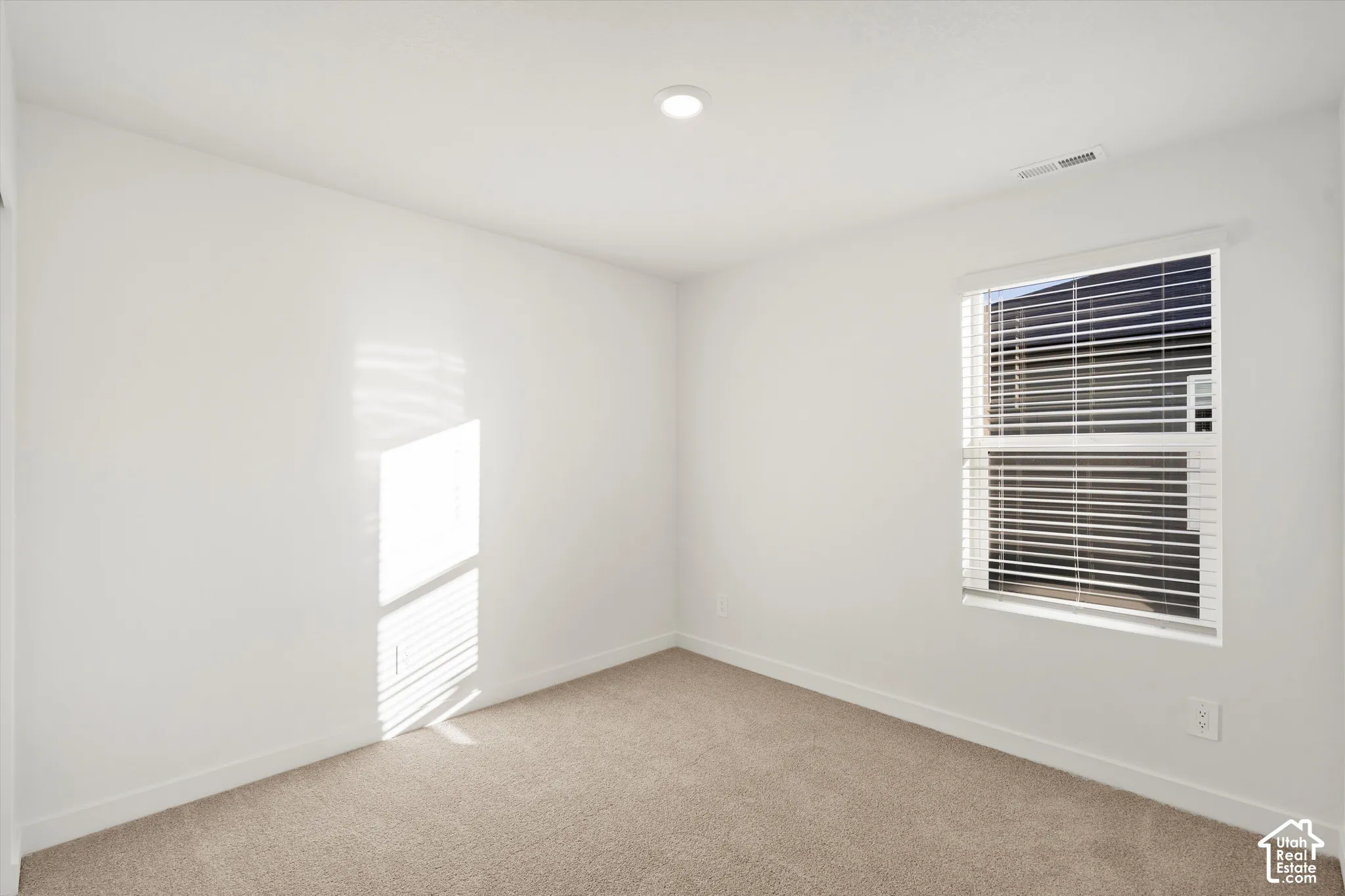 **Disclaimer** Interior package & colors may vary.  Neutral interior space featuring high ceilings, wall-to-wall carpeting, and a single-hung window with horizontal blinds