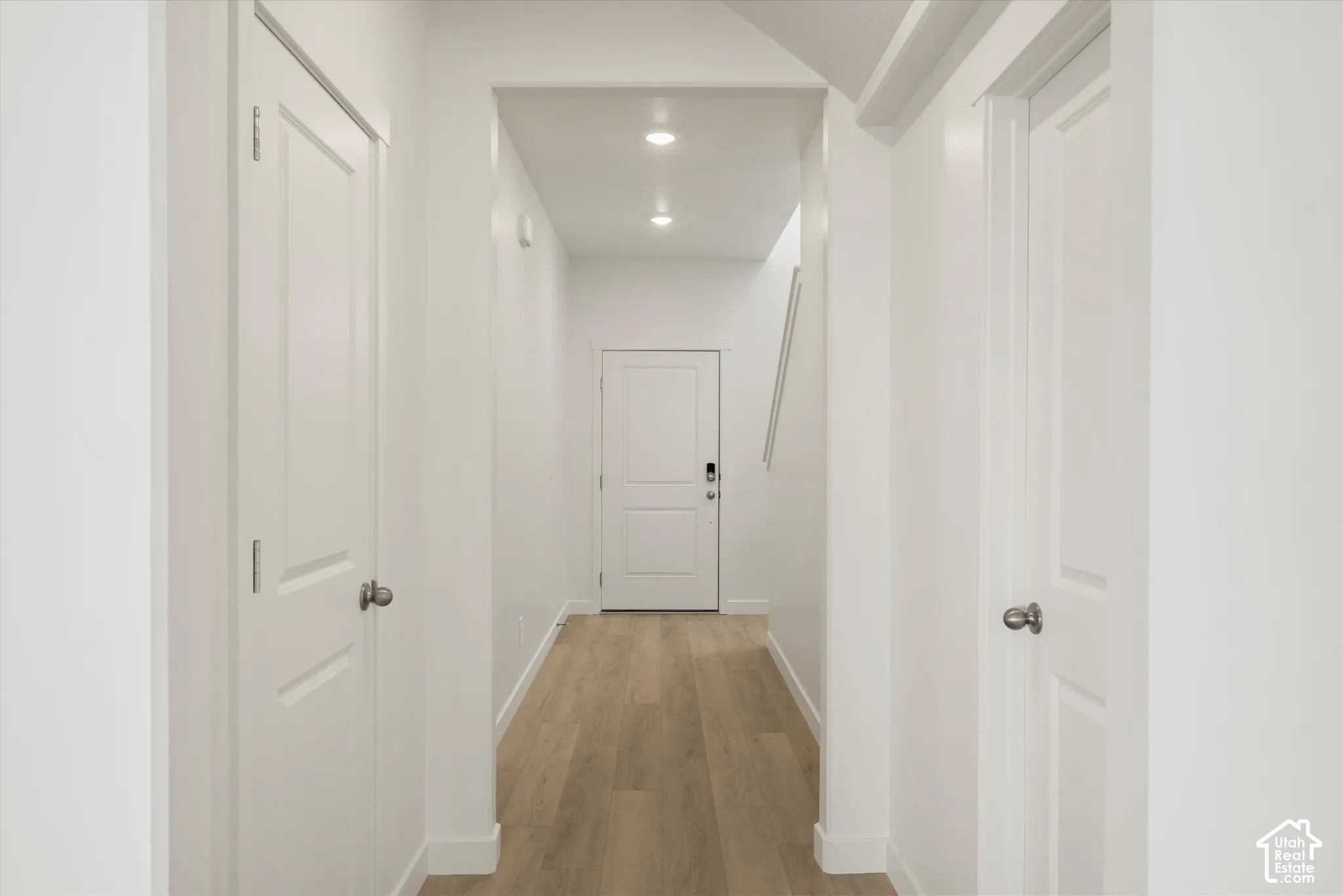 **Disclaimer** Interior package & colors may vary.  Interior hallway featuring wood-finish flooring, recessed lighting, and white multi-panel doors with metallic hardware