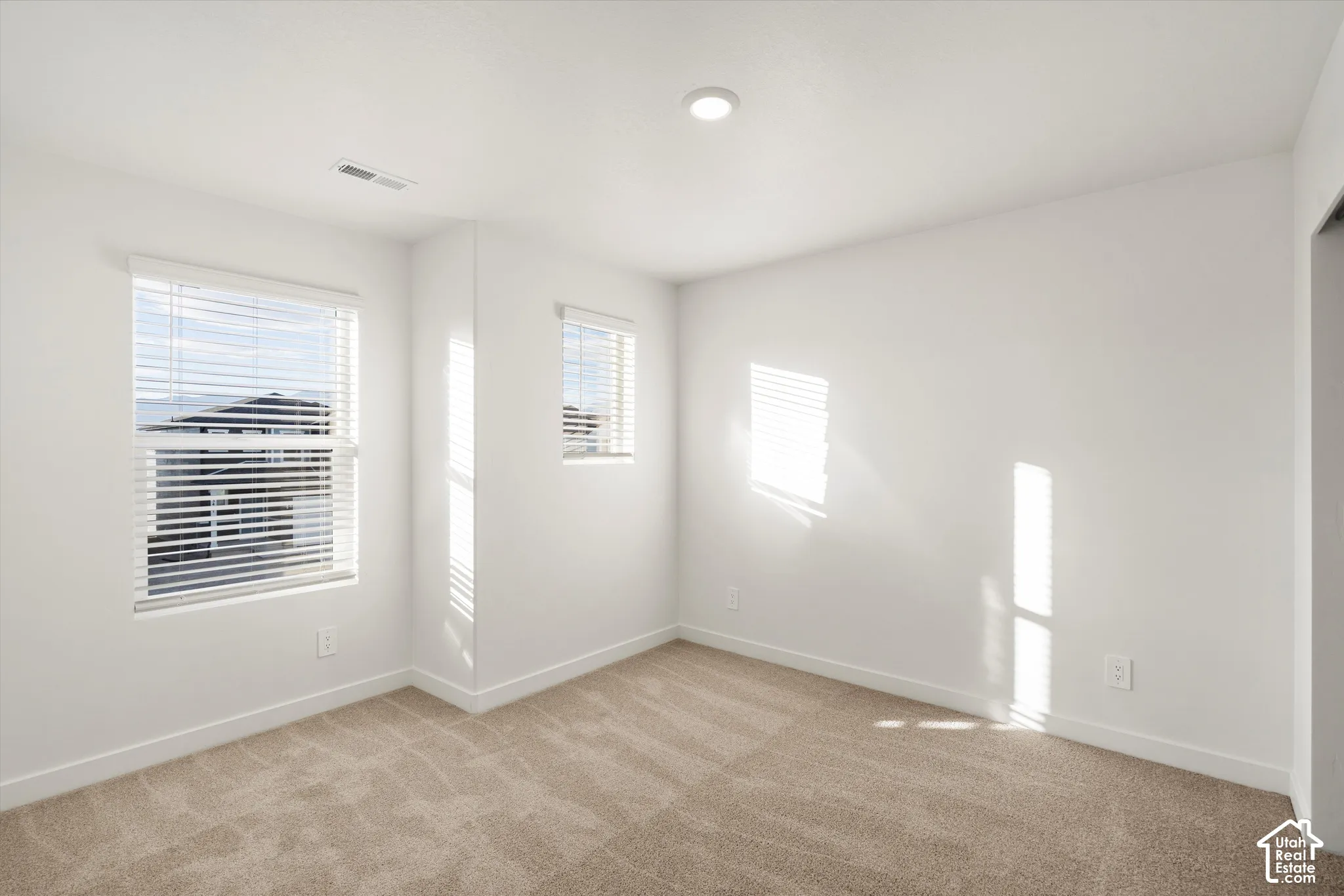 **Disclaimer** Interior package & colors may vary.  Neutral-toned wall-to-wall carpeting, crisp white walls, dual windows with fitted blinds, and recessed lighting