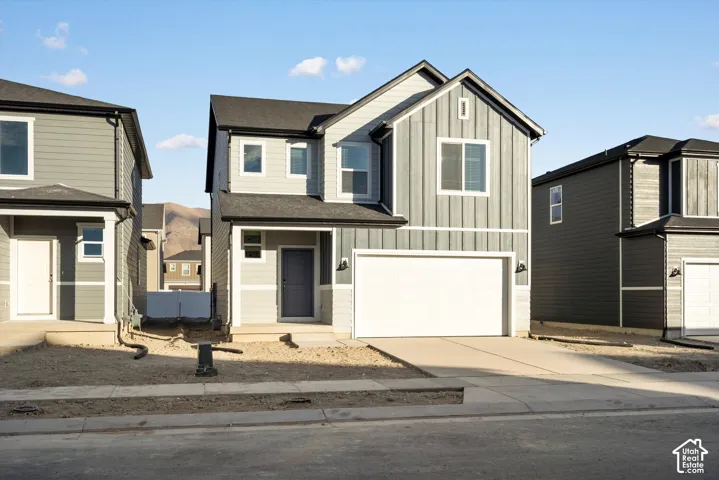 **DISCLAIMER** Elevation and exterior colors may vary.  Two-story residence featuring vertical and horizontal siding, a composite shingle roof, and an attached two-car garage