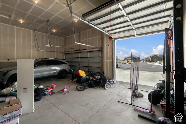 Multi-car garage featuring high ceilings, concrete flooring, and an automated sectional overhead door