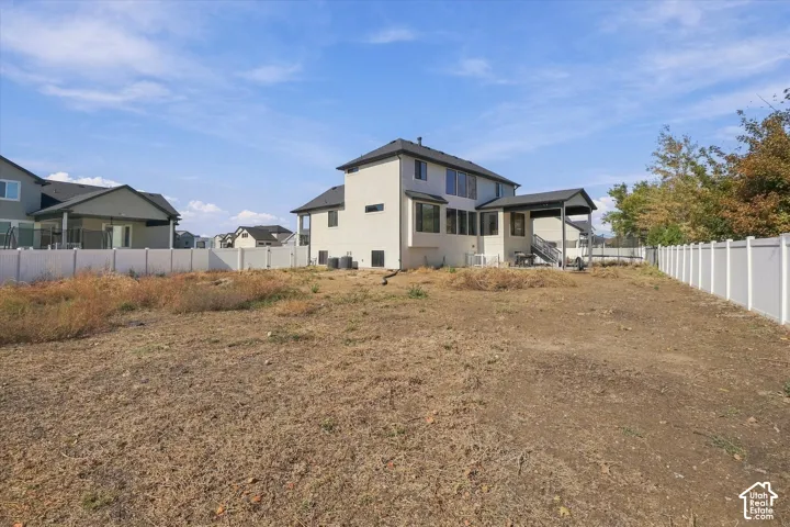 Expansive lot featuring a full-perimeter white vinyl fence and a rear covered patio