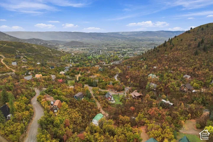 Aerial perspective featuring expansive mountain terrain, rolling hills, and mature deciduous vegetation