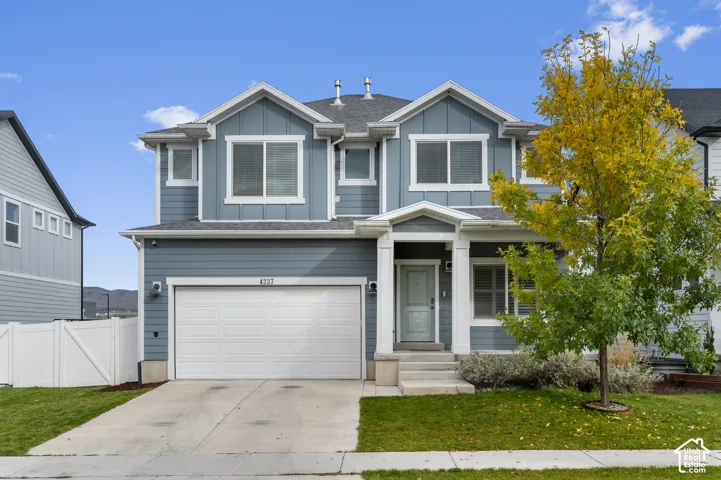 Two-story residence featuring horizontal and board-and-batten siding, a gabled roofline with dual dormers, an attached two-car garage, and a covered front entry porch with structural columns